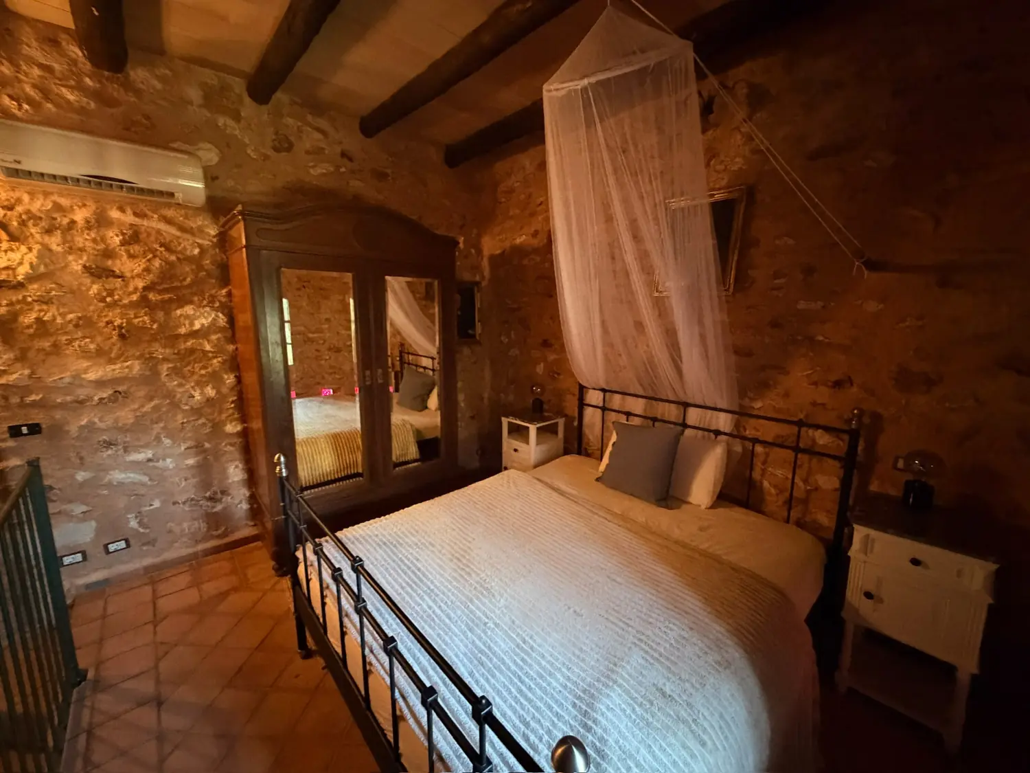 Canopy bed in a stone-walled room